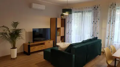 a living room with a green couch and a television at Domek Zielone Marzenie in Chrzanów