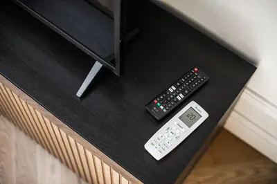 a remote control and a thermometer on a table at Królewska Deluxe Comfy Apartment by BookingHost in Kraków
