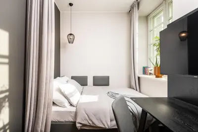 a small bedroom with a bed and a table at MILESTONE Krakow Center Premium Living by Tribera in Kraków