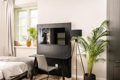 a bedroom with a bed and a tv on a wall at MILESTONE Krakow Center Premium Living by Tribera in Kraków