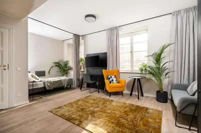 an apartment living room with a yellow chair and a desk at MILESTONE Krakow Center Premium Living by Tribera in Kraków