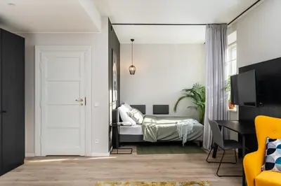 a bedroom with a bed and a table with a yellow chair at MILESTONE Krakow Center Premium Living by Tribera in Kraków