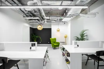 an office with white tables and a green chair at MILESTONE Krakow Center Premium Living by Tribera in Kraków