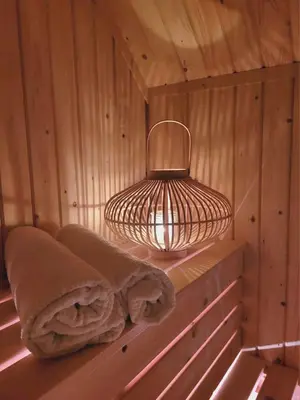 a light in a sauna with towels on a shelf at Szczyt Beztroski- Domki Wellness Balia & Sauna in Nowy Targ