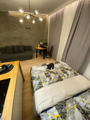 a bedroom with a bed and a couch and a table at Love Glow Studio in Kraków