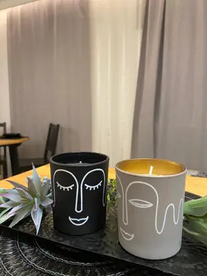 two cups sitting on a table with a candle at Love Glow Studio in Kraków