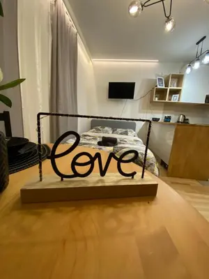 a bedroom with a bed with the word love on it at Love Glow Studio in Kraków
