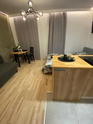 a living room with a bed and a table in it at Love Glow Studio in Kraków