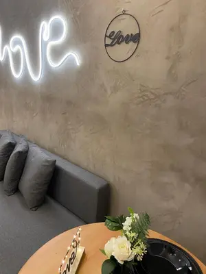a table and a couch in a room with neon signs at Love Glow Studio in Kraków