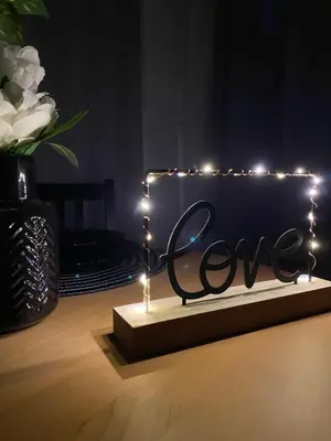 a sign that says love with lights on a table at Love Glow Studio in Kraków