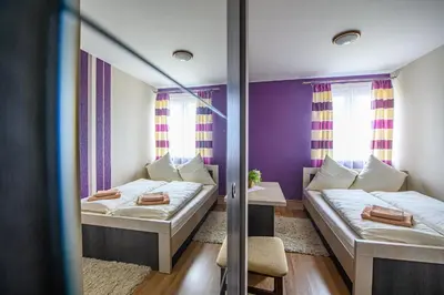 two beds in a room with purple walls and windows at Hotel Restauracja Sara in Laskowa
