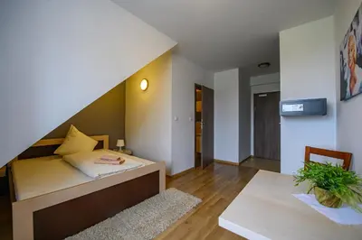 a small bedroom with a bed and a table at Hotel Restauracja Sara in Laskowa