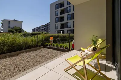 a yellow chair sitting on a patio next to a building at Kraków Studio with Parking & Terrace near Zalew Bagry by Renters Prestige in Kraków