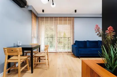 a living room with a table and chairs and a blue couch at City of the Kings-Julia Apartment in Kraków