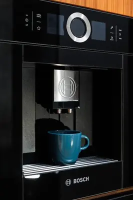 a black microwave with a blue cup in it at City of the Kings-Julia Apartment in Kraków