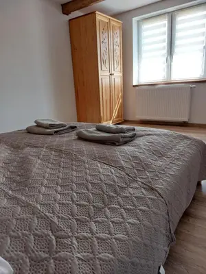 a bedroom with a bed with two towels on it at Agroturystyka ,Jarzębina' in Harkabuz
