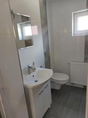 a white bathroom with a sink and a toilet at Agroturystyka ,Jarzębina' in Harkabuz