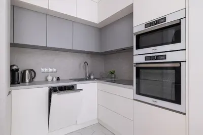 a white kitchen with white cabinets and a microwave at Vetulaniego Apartment with Air Conditioning & Parking by Renters Prestige in Kraków