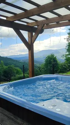 a hot tub with a view of the mountains at Zawoja u Zbója in Zawoja
