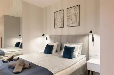 a bedroom with two beds with blue pillows at Modern Apartment with Air Conditioning, Old Town & Vistula River in Kraków
