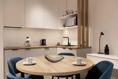 a kitchen with a wooden table and blue chairs at Modern Apartment with Air Conditioning, Old Town & Vistula River in Kraków