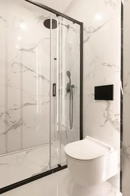 a white bathroom with a shower and a toilet at Modern Apartment with Air Conditioning, Old Town & Vistula River in Kraków