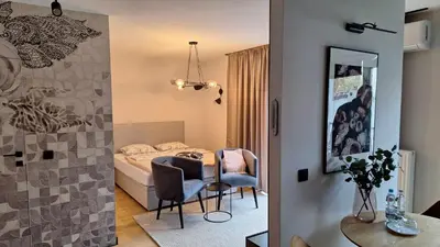 a bedroom with a bed and a table and chairs at Apollo Apartments Masarska 6 in Kraków