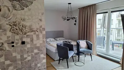 a bedroom with a bed and two chairs and a table at Apollo Apartments Masarska 6 in Kraków