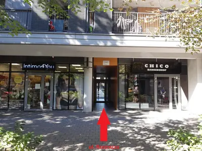 a red arrow pointing into a building with a store at Apollo Apartments Masarska 6 in Kraków
