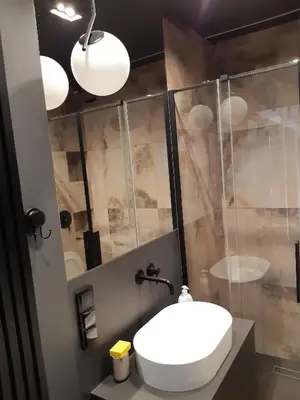 a bathroom with a white sink and a shower at Apollo Apartments Masarska 6 in Kraków