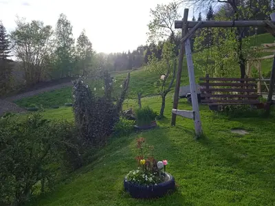 a garden with flowers and a swing in the grass at Wypoczynek u Agnieszki in Ochotnica Górna