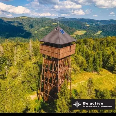 a wooden observation tower in the middle of a field at Wypoczynek u Agnieszki in Ochotnica Górna