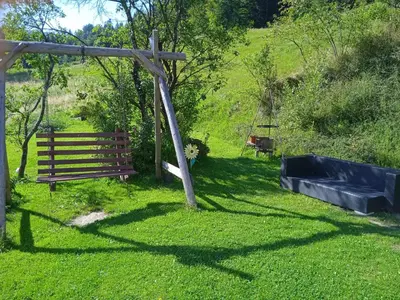 a garden with a wooden fence and a swing at Wypoczynek u Agnieszki in Ochotnica Górna