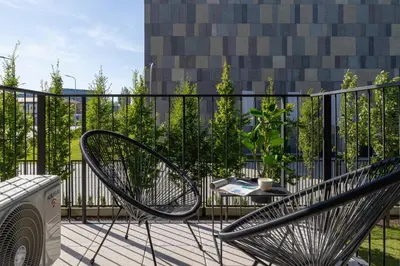 a metal bench sitting on a balcony with a table at Beautiful Steam Park Apartment with Parking Old Town Cracow by Noclegi Renters in Kraków