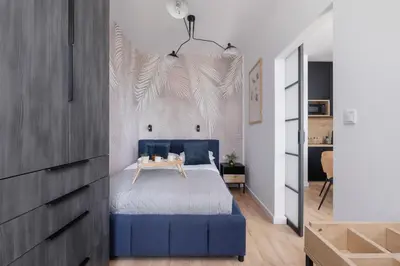 a bedroom with a blue bed with a table on it at Beautiful Steam Park Apartment with Parking Old Town Cracow by Noclegi Renters in Kraków