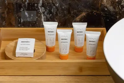 four bottles of sunscreen on a wooden tray at Beautiful Steam Park Apartment with Parking Old Town Cracow by Noclegi Renters in Kraków