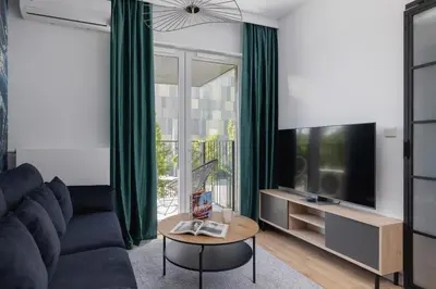 a living room with a couch and a tv and a table at Beautiful Steam Park Apartment with Parking Old Town Cracow by Noclegi Renters in Kraków