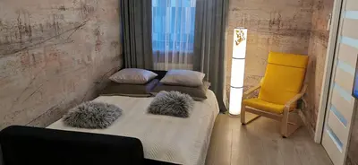 a bedroom with two beds and a yellow chair at COMFORT Apartment Pawia street - free parking !!! in Kraków