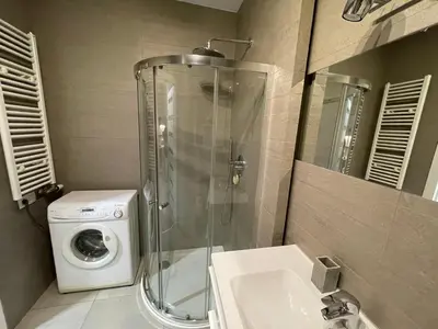 a bathroom with a shower and a washing machine at COMFORT Apartment Pawia street - free parking !!! in Kraków