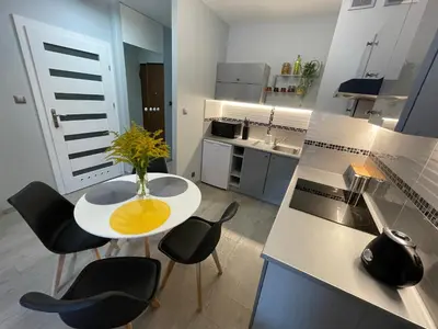 a kitchen with a white table and black chairs at COMFORT Apartment Pawia street - free parking !!! in Kraków