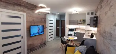 a living room with a table and a kitchen at COMFORT Apartment Pawia street - free parking !!! in Kraków