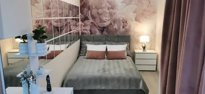 a bedroom with a bed and a wall with flowers at COMFORT Apartment Pawia street - free parking !!! in Kraków