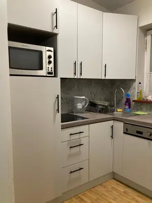 a kitchen with white cabinets and a microwave at Old Town Sky Apartment in Kraków