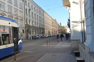 a bus driving down a city street with buildings at Old Town Sky Apartment in Kraków