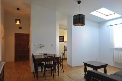 a dining room and living room with a table and chairs at Old Town Sky Apartment in Kraków