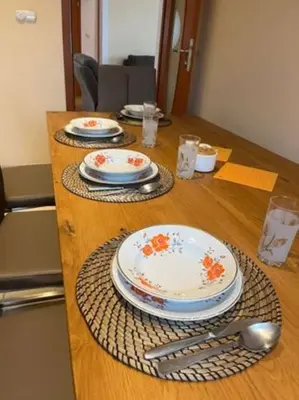 a wooden table with plates and utensils on it at Noclegi Wilga in Gromiec