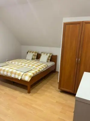 a bedroom with a bed and a wooden cabinet at Noclegi Wilga in Gromiec