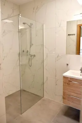 a bathroom with a shower with a glass door at Dobranocka Noclegi - blisko Energylandia in Spytkowice