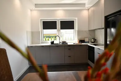 a white kitchen with a sink and a window at Dobranocka Noclegi - blisko Energylandia in Spytkowice