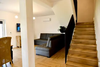 a living room with a couch and a staircase at Dobranocka Noclegi - blisko Energylandia in Spytkowice